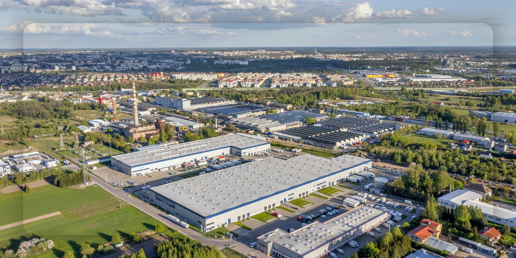 Luftansicht eines Gewerbegebiets mit Hallen und Zufahrten