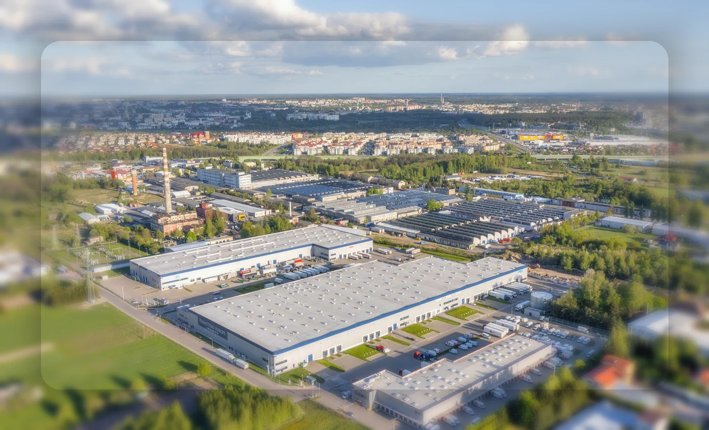 Betriebsareal mit Hallen und umliegenden Flächen aus der Luft